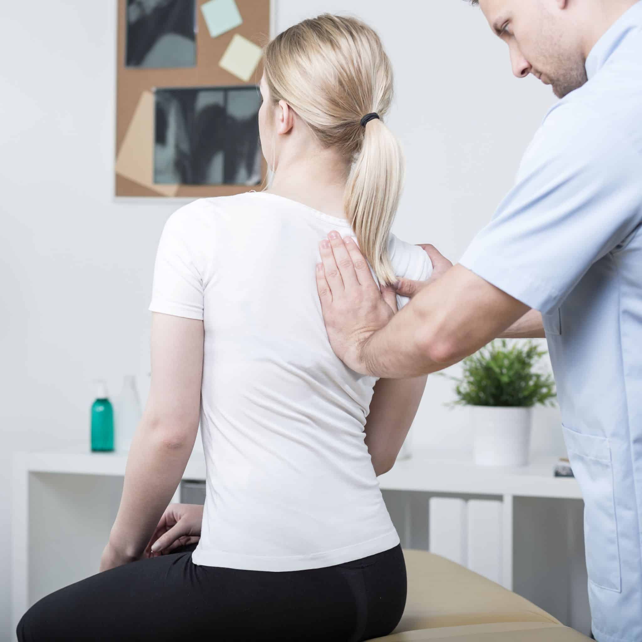 Chiropractic care adjustments being performed by a chiropractor in the patient’s right shoulder and upper back.