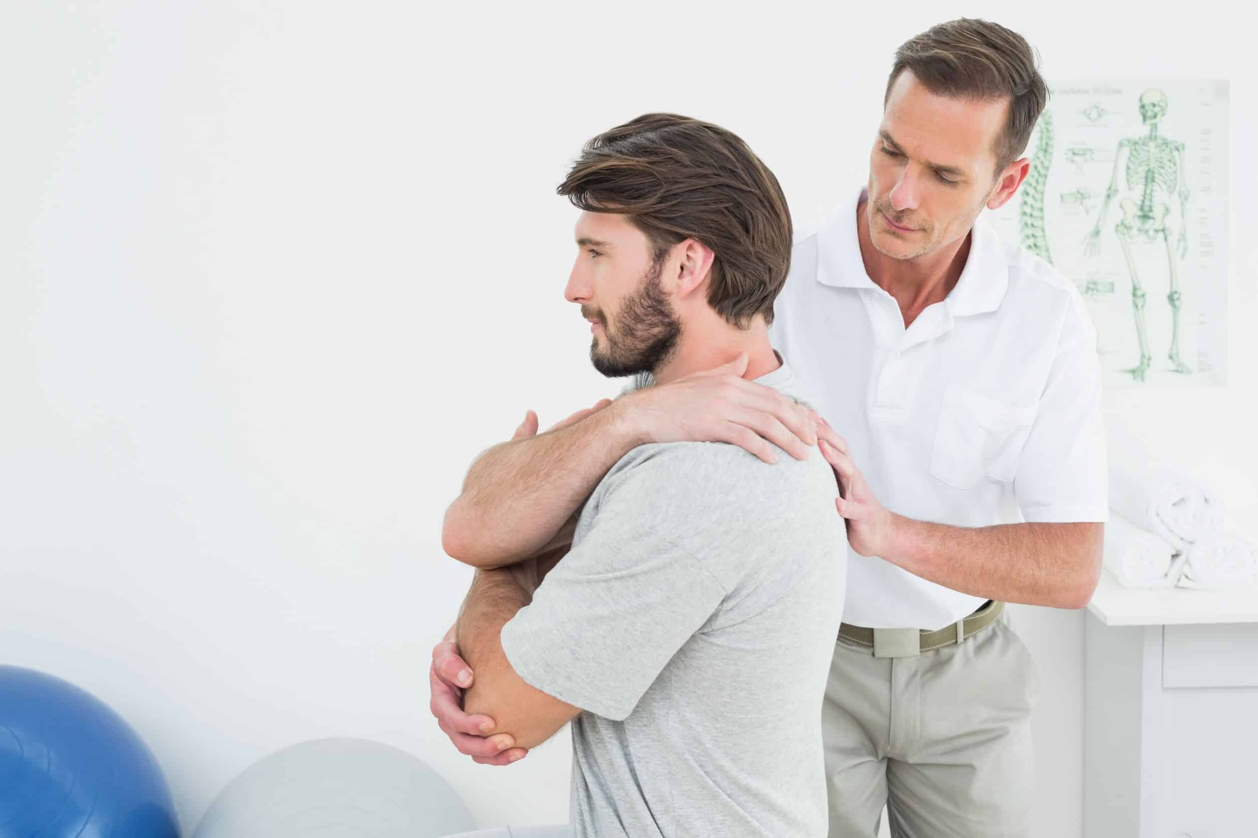 Chiropractic care adjustments being performed by a chiropractor in a male patient’s shoulder and upper back.